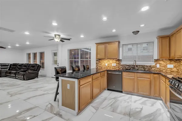 a kitchen with stainless steel appliances granite countertop a stove sink and cabinets