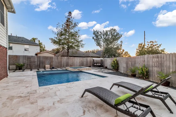 a view of a backyard with couches plants and wooden fence