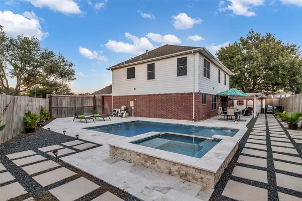 a view of a house with pool and sitting area