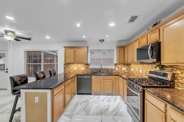 a kitchen with granite countertop a sink stove top oven and granite counter top