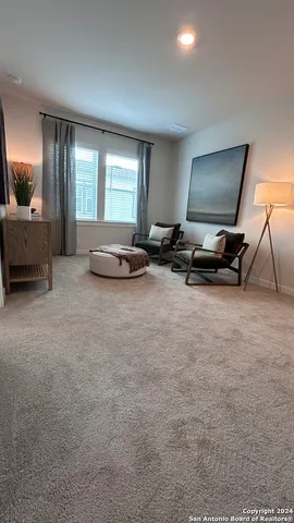 a living room with furniture a flat screen tv and a window