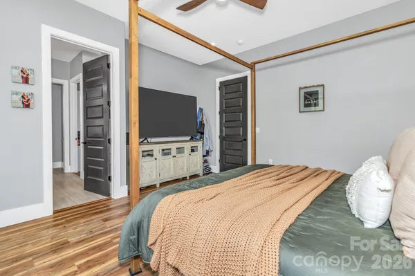 a bedroom with a bed and a flat screen tv