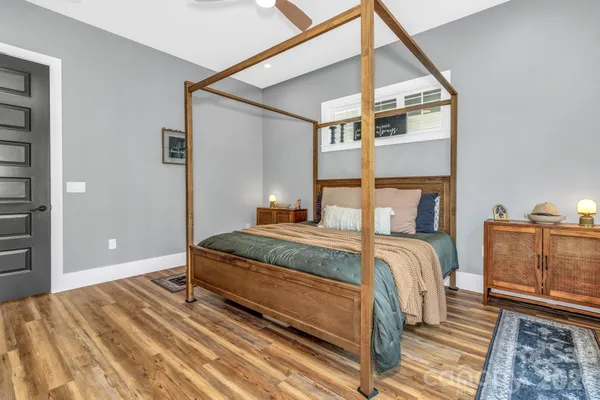 a bedroom with a bed and wooden floor
