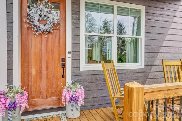 a front view of a house with wooden floor and potted plants