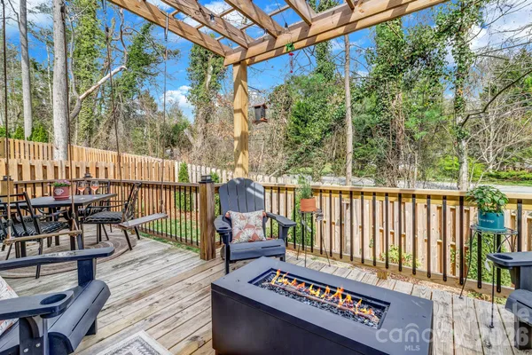 a balcony with wooden floor outdoor seating and yard in the back