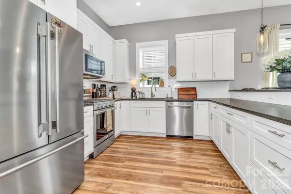 a kitchen with white cabinets stainless steel appliances and sink