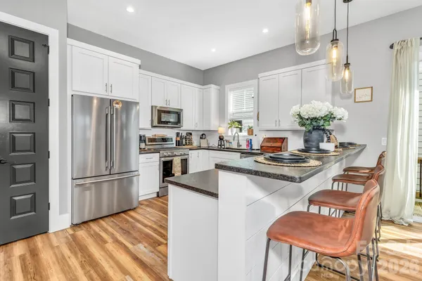 a kitchen with granite countertop a refrigerator stove top oven and sink