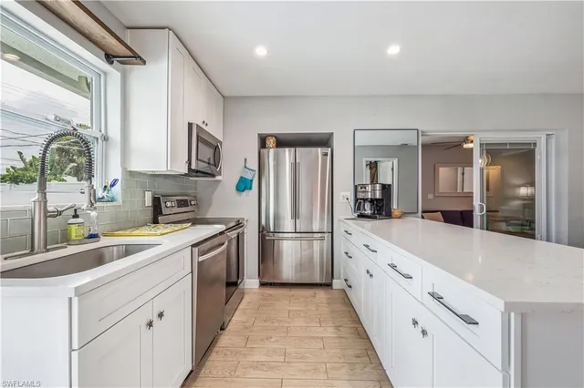 a kitchen with white cabinets and appliances