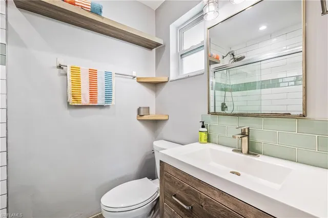 a bathroom with a sink a toilet and window