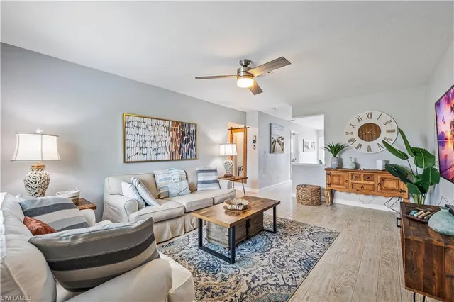 a living room with furniture a rug and a lamp