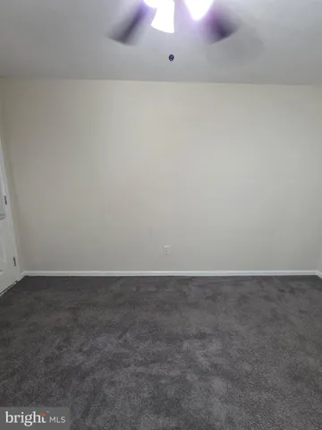 en empty room with windows and fan