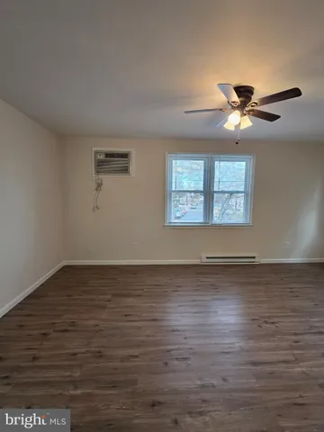 a view of a room with wooden floor and a ceiling fan