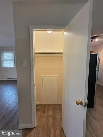 an empty room with wooden floor and a window