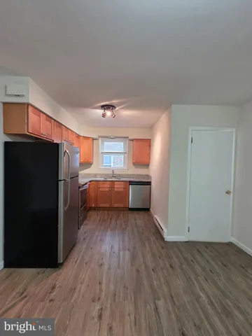 a view of a kitchen with wooden floor and electronic appliances