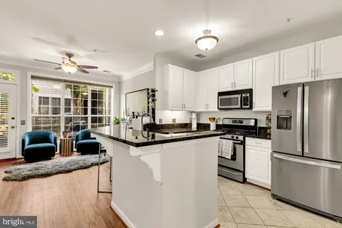 a kitchen with granite countertop a sink stainless steel appliances and cabinets