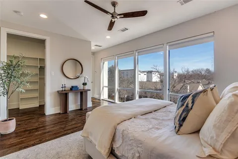 a bedroom with a bed mirror and window