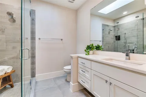 a bathroom with a sink a toilet and shower
