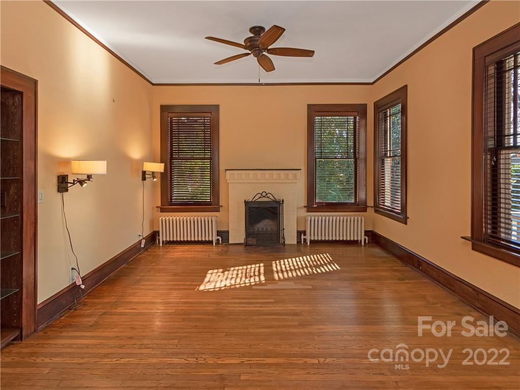 218 West Main Street Brevard, NC 28712 - Photo 18 of 48 a living room with a fireplace furniture a ceiling fan and a window