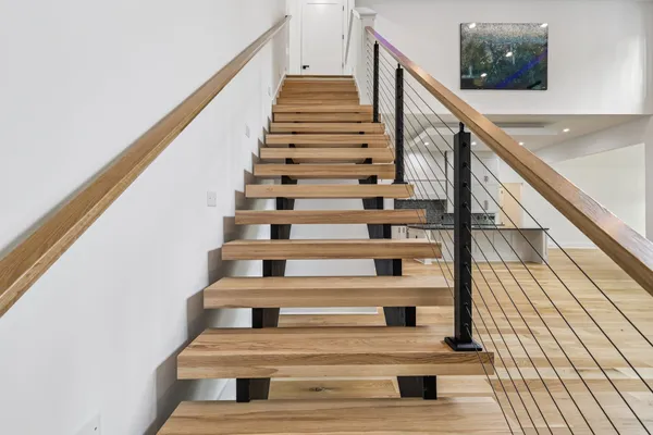 a view of a hallway with wooden floor and staircase
