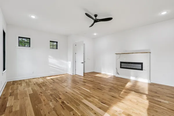 a view of an empty room with a window and a fireplace