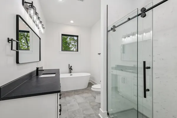 a bathroom with a granite countertop shower and a mirror