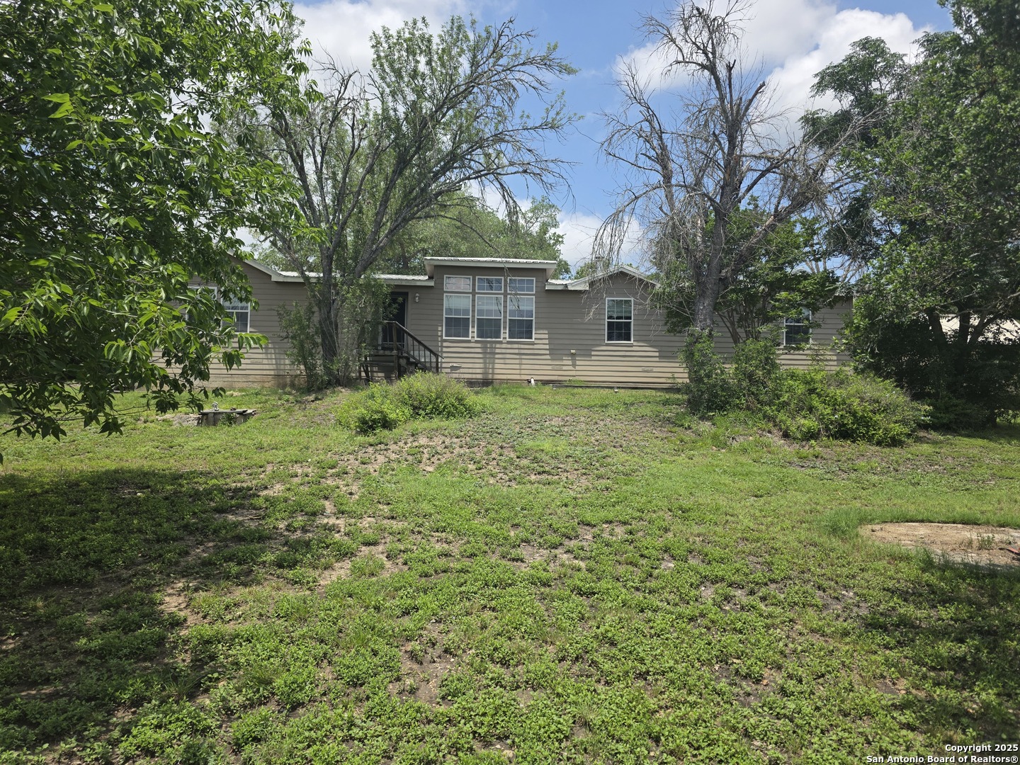 7940 County Road 279 Rio Medina, TX 78066 - Photo 2 of 33 a view of a house with yard and trees in the background