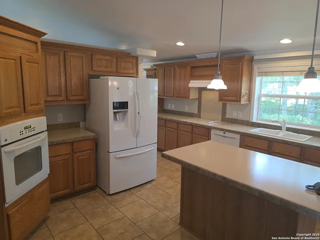a kitchen with a refrigerator sink and cabinets