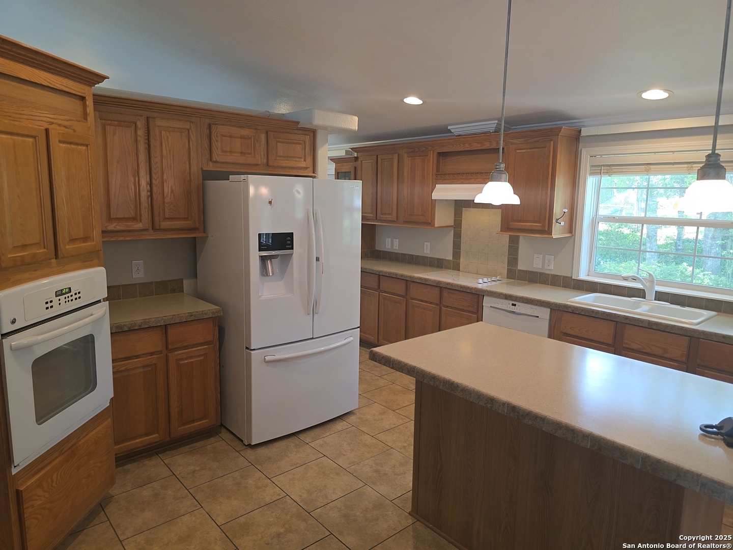 7940 County Road 279 Rio Medina, TX 78066 - Photo 6 of 33 a kitchen with a refrigerator sink and cabinets