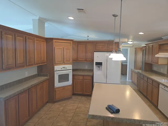 a kitchen with stainless steel appliances granite countertop a refrigerator a sink and a stove