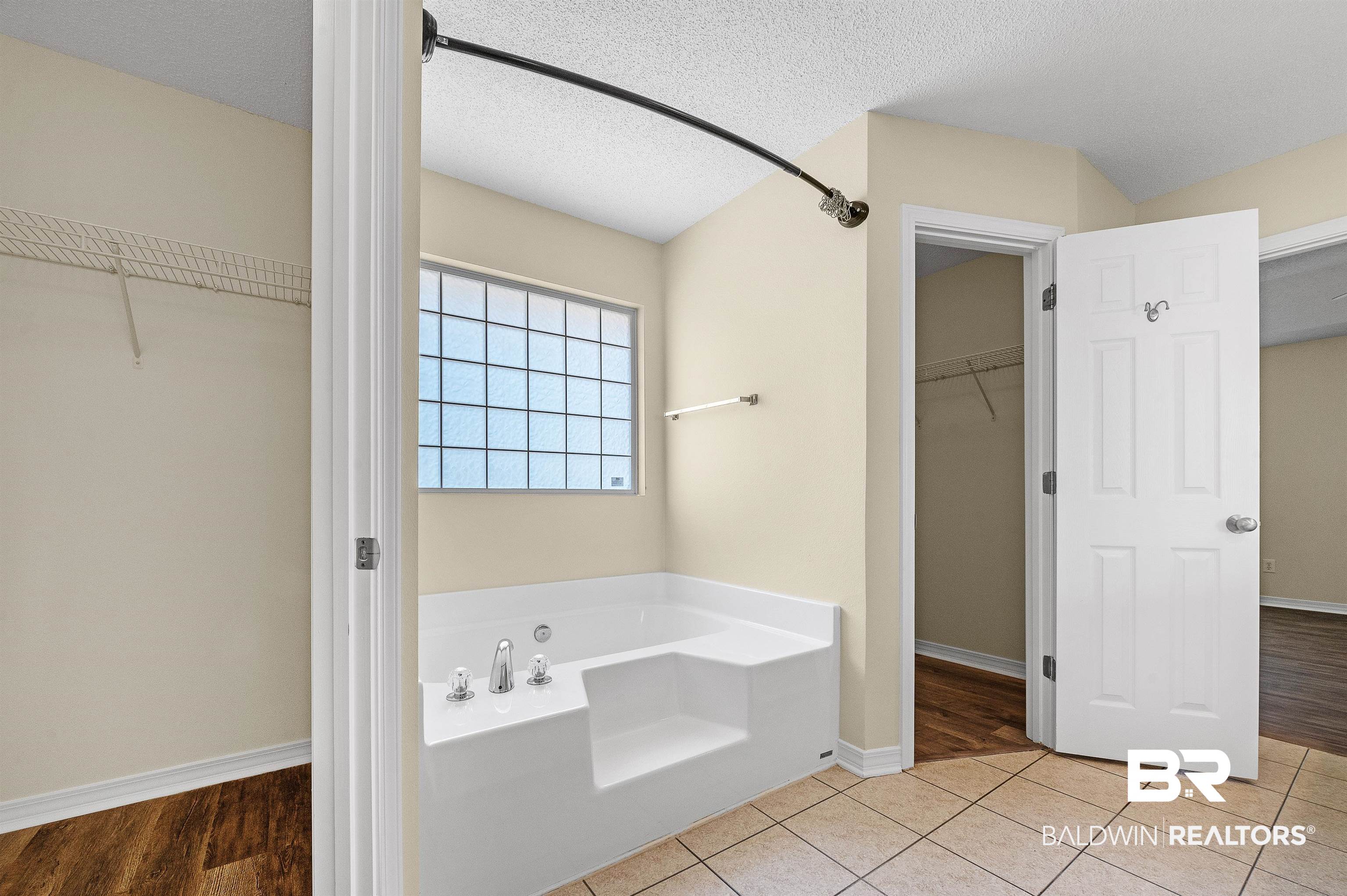12443 Venice Boulevard Foley, AL 36535 - Photo 47 of 59 Bathroom with a tub, hardwood / wood-style floors, and a textured ceiling