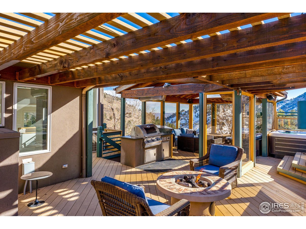 5339 Olde Stage Road Boulder, CO 80302 - Photo 4 of 40 Outdoor living at it's best... Outdoor kitchen, refrigerator, commercially heated enclosed sitting area, shaded portico with gas fireplace.