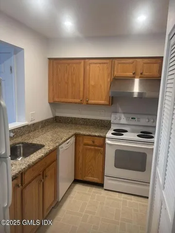 a kitchen with granite countertop a sink and a stove top oven