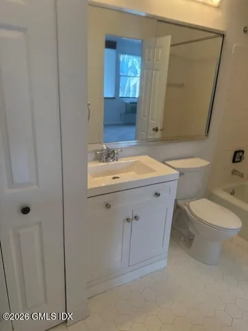 a bathroom with a sink a toilet and mirror