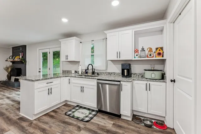 a kitchen with granite countertop white cabinets and white appliances