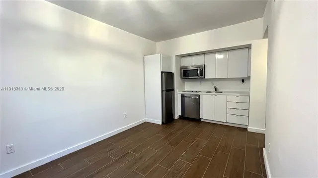 a view of a kitchen with wooden floor and electronic appliances