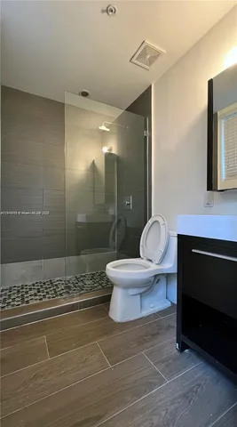 a bathroom with a sink a toilet a mirror and shower