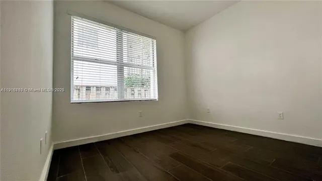 an empty room with wooden floor and a window