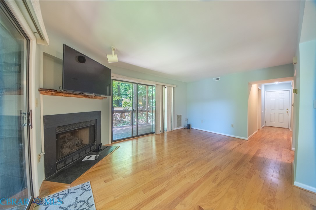 54 Villa Ridge Drive, Unit C Hartfield, VA 23071 - Photo 41 of 45 Unfurnished living room featuring a fireplace with flush hearth and light wood-type flooring