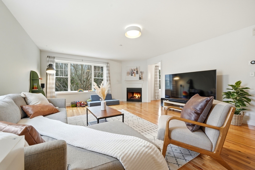a living room with furniture a flat screen tv and a large window