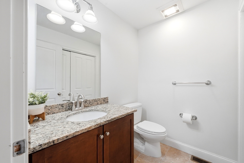30 Webster Street, Unit 3 Needham, MA 02494 - Photo 24 of 38 a bathroom with a granite countertop sink a toilet and a mirror