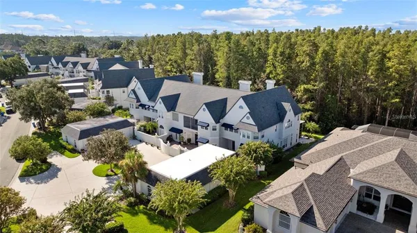 an aerial view of a house with a yard and mountain view in back