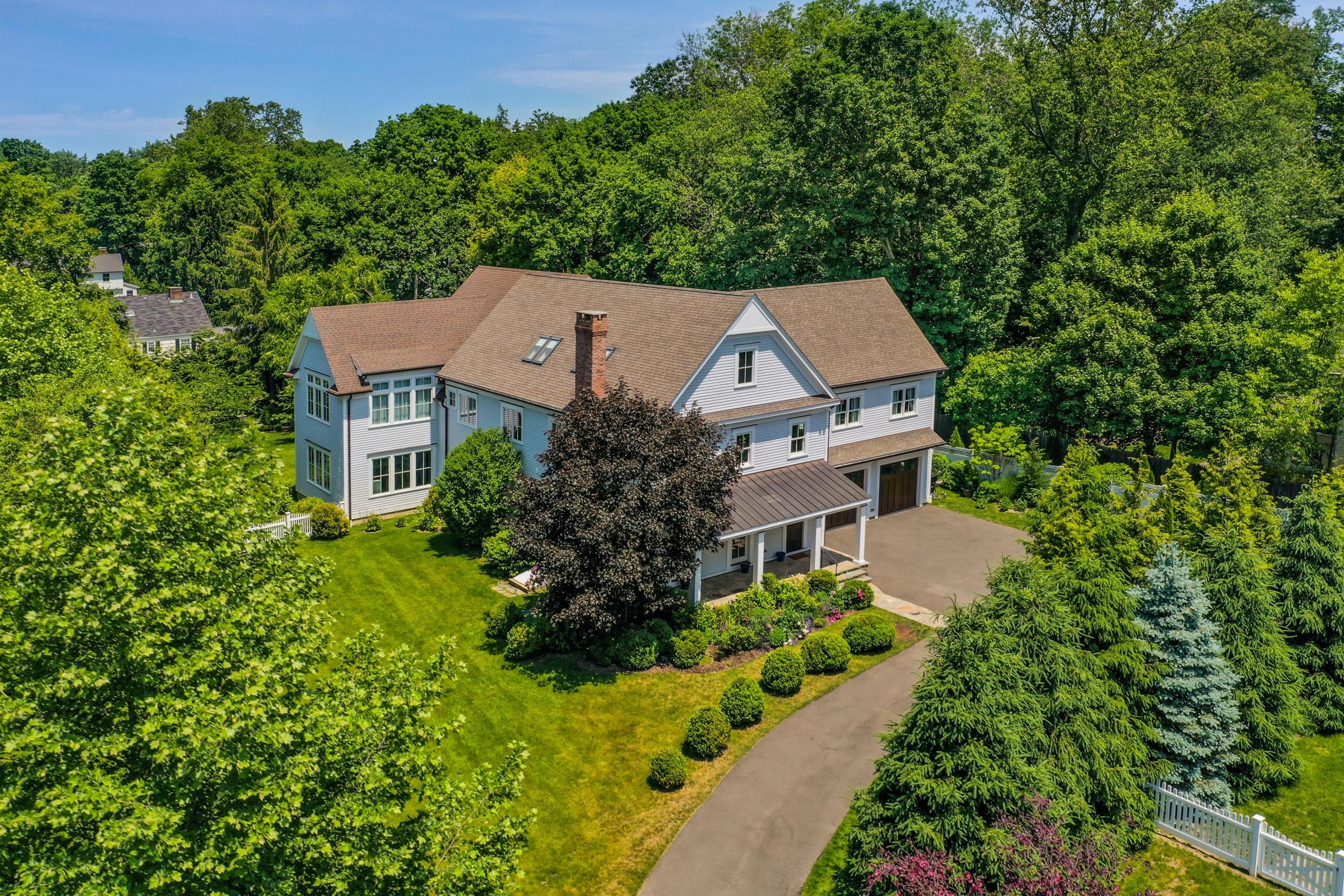 an aerial view of a house with a yard and large trees