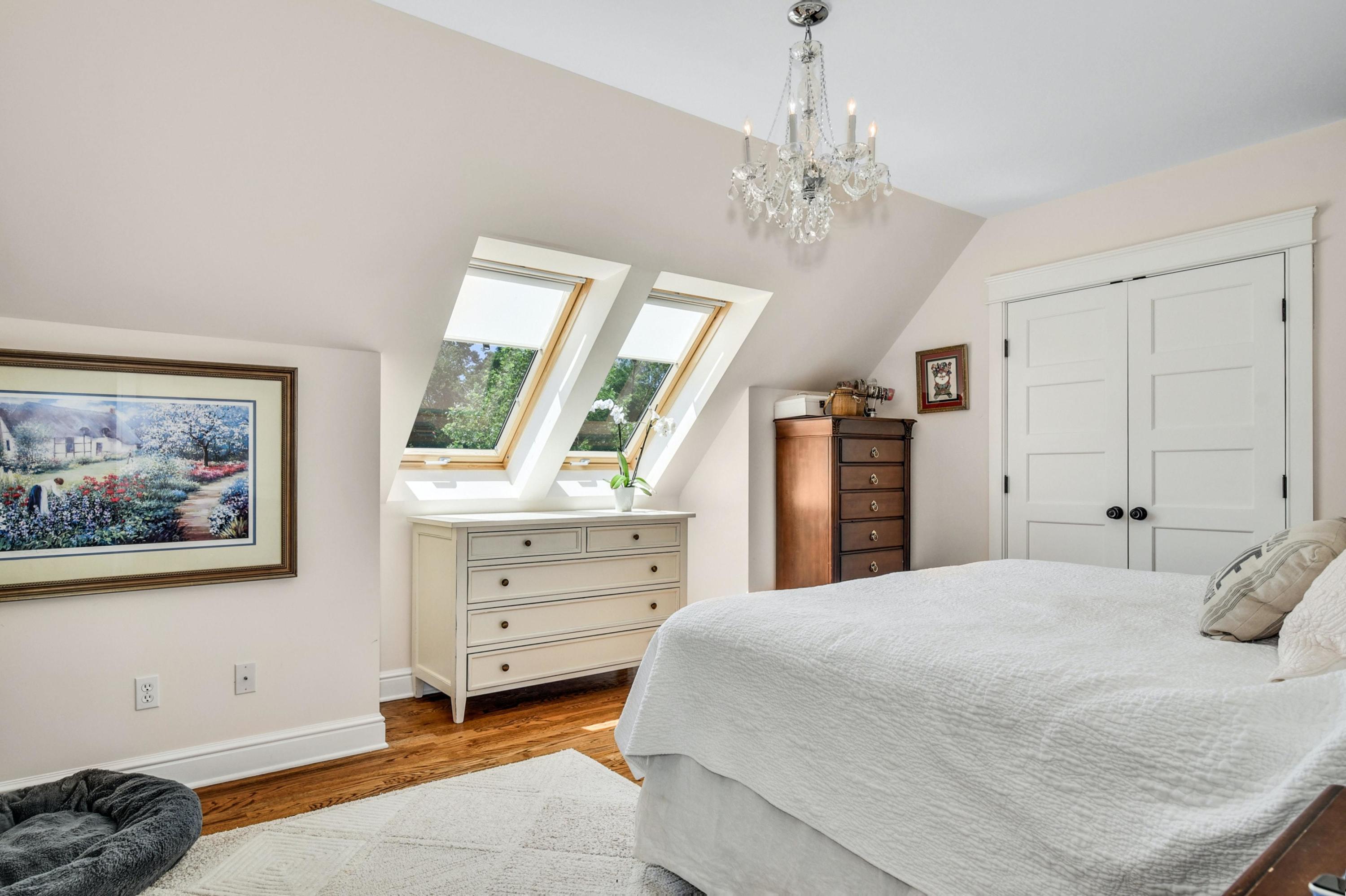2271 Boston Post Road Darien, CT 06820 - Photo 24 of 40 a spacious bedroom with a bed and a chandelier