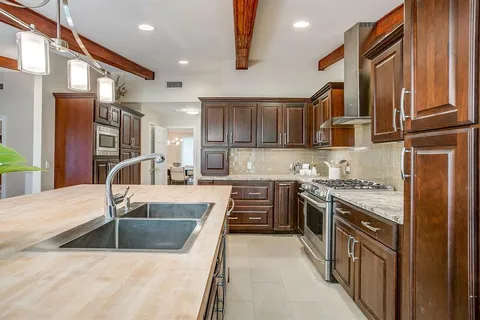 a kitchen with stainless steel appliances granite countertop a sink stove and refrigerator