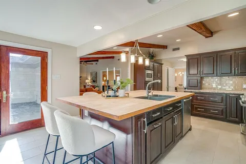 a large kitchen with a table and chairs