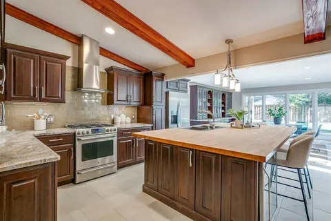 a kitchen with kitchen island granite countertop a stove and a sink
