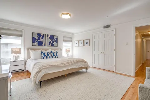 a spacious bedroom with a bed and a cabinets