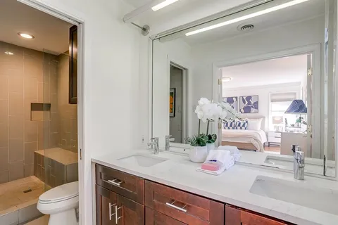 a bathroom with a granite countertop sink and a mirror