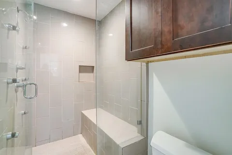 a bathroom with a shower a toilet and sink