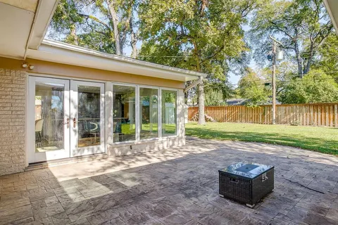 a backyard of a house with barbeque oven and floor to ceiling window